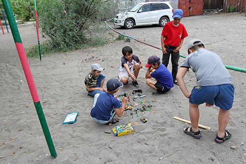 Ржавеющие остовы бывших совковых качелей, между ними местная ребятня выдумывает себе занятия...