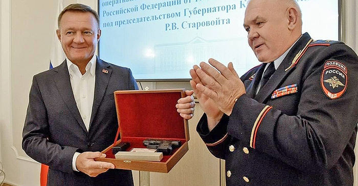 Роман Старовойт радуется подаренному пистолету